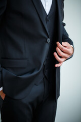 Stylish man businessman buttoning a button on a black jacket