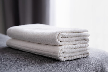 Fototapeta na wymiar Hotel staff, fresh white bath towels on the bed. Room cleaning service.