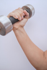 A girl working out with a pair of dumbbells, perfect for biceps (Close up)