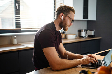 Young man working remotely and heaving a meeting