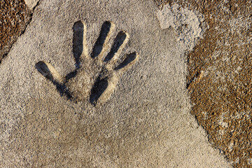 Grey stone wall with a human hand right palm print mark - Powered by Adobe