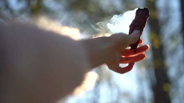 Smudging sage by holding up a small smoldering bundle of sage to purify the area and promoting physical, emotional and mental health - slow motion