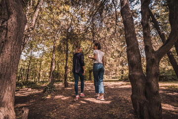 Fototapeta premium Two happy young women having coffee break together in park