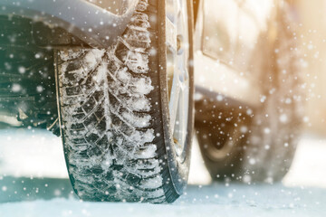 Close-up of car wheels rubber tires in deep winter snow. Transportation and safety concept.