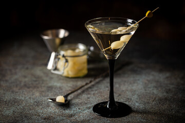 Gibson alcohol cocktail with martini and onions in martini glass. Decorated cocktail on dark background - obrazy, fototapety, plakaty