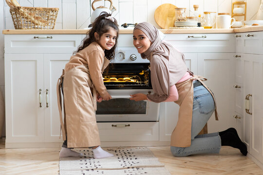 Portrait Of Happy Muslim Family Mother And Daughter Baking Together In Kitchen