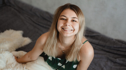 Beautiful smiling blonde in green pajamas. Good happy morning concept