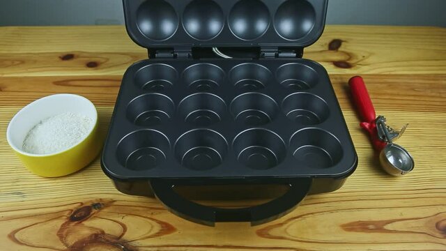 top view at open black backer machine for made muffins served on wooden table