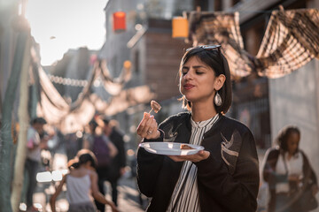 Beautiful young female tourist in city of Paris France enjoying holidays in beautiful little street festival eating street food