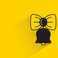 bell and bow tie shadow on yellow background
