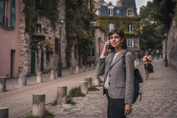 Fototapeta premium Young urban business woman talking on phone on city street 