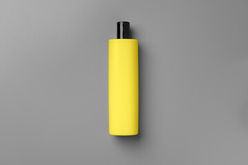 Yellow cosmetic container on gray background top view