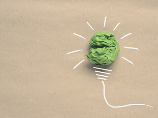 Recycled paper background with green crumpled paper ball as light bulb, ecology concept,...