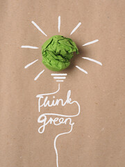 Recycled paper background with green crumpled paper ball as light bulb, ecology concept,...