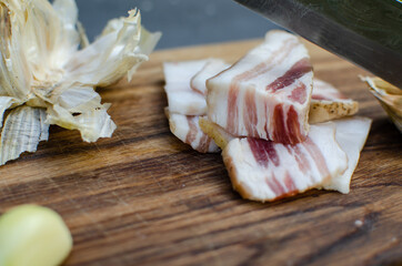 Raw chopped pork lard with meat on a wooden background for copy space. A large chunk of fresh fat. Ukrainian lard, traditional food.
