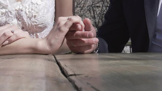 Newlyweds caress their hands with rings on their fingers.
