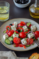 Greek salad with tomatoes, cucumbers, cheese, onions, peppers and olives. Healthy eating. Vegetarian food.