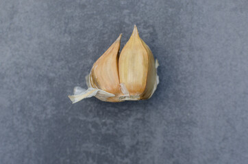 Garlic on a gray background. Dry spice. Healthy food concept, folk medicine, harvest, copy space