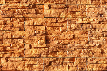 Orange stone background and texture of weathered tiles in harsh sunlight.
