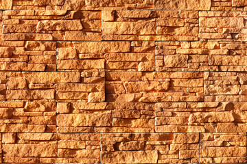 Orange stone background and texture of weathered tiles in harsh sunlight.