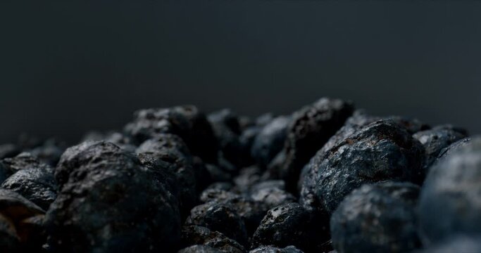 Amazing natural phenomena. Mound of unusual black stones on black background. High quality.