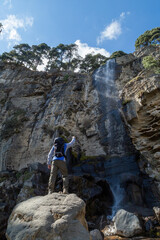 Male hiker standing on a rock near a waterfall in the Iztaccihuatl Mountain in Mexico