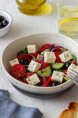 Greek salad with tomatoes, cucumbers, cheese, onions, peppers and olives. Healthy eating. Vegetarian food.