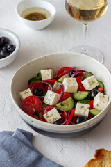Greek salad with tomatoes, cucumbers, cheese, onions, peppers and olives. Healthy eating. Vegetarian food.