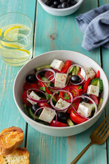 Greek salad with tomatoes, cucumbers, cheese, onions, peppers and olives. Healthy eating. Vegetarian food.