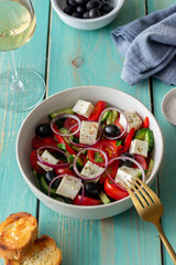Greek salad with tomatoes, cucumbers, cheese, onions, peppers and olives. Healthy eating. Vegetarian food.