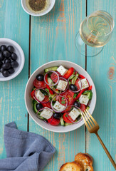Greek salad with tomatoes, cucumbers, cheese, onions, peppers and olives. Healthy eating. Vegetarian food.