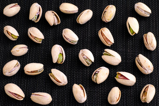 A lot of Pistachio nuts on black napkin