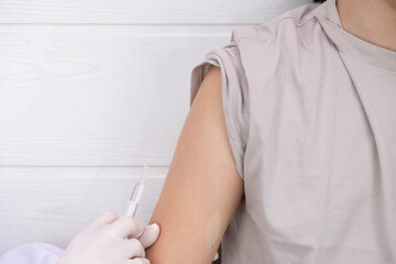 doctor in white gloves preparing to vaccinate a teenager