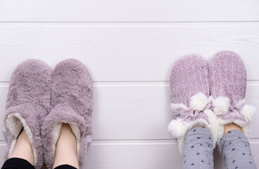 raised up legs of two girls in warm slippers