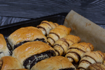 Rich pastries. The buns are on a baking sheet. Filling with poppy seeds, walnuts. Close-up shot.