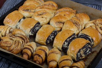 Rich pastries. The buns are on a baking sheet. Filling with poppy seeds, walnuts. Close-up shot.