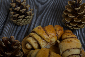 Cinnamon croissants. Rich pastries. Nearby pine cones. Close-up shot.