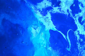 Blue abstract marble background. The acrylic paint mixes freely and creates an interesting pattern....