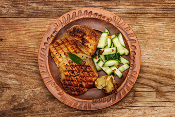 Grilled pork meat with baked garlic and fresh cucumber