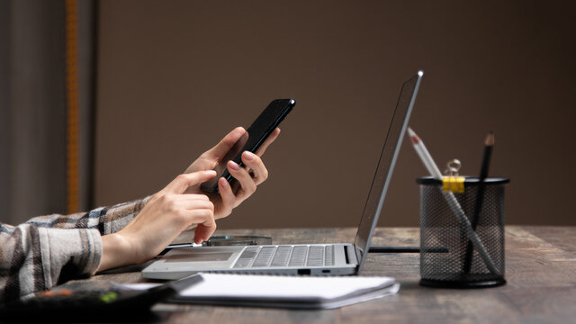 Cropped image of professional businesswoman working at her office via laptop, young female manager using portable computer device while sitting at modern loft, flare light, work process concept