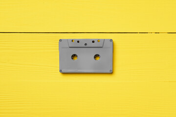 Gray audio cassettes on yellow background top view