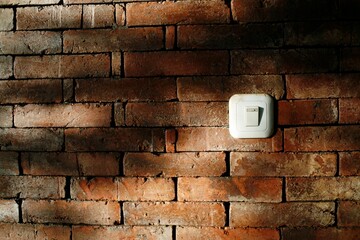 electrical outlet on a wall. light switch on the brick wall