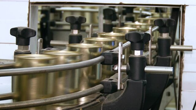 Metal containers at a dairy factory. Moving conveyor