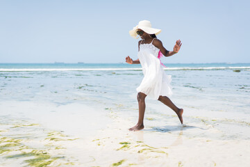 Fototapeta na wymiar Beautiful young black African American woman on the tropical beach