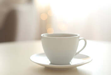 Cup of aromatic coffee on table indoors. Bokeh effect
