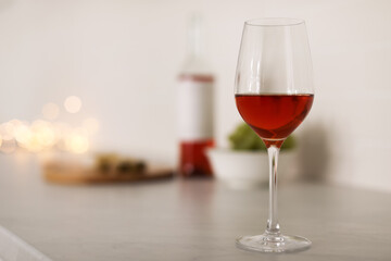 Glass of delicious wine on table, space for text. Bokeh effect