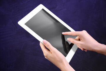 Woman using modern tablet on blue background, closeup