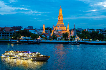 Naklejka premium Chao Phraya River Cruise Boat with Temple of the Dawn, Wat Arun, at Sunset in Background, Horizontal