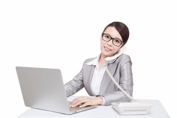 Portrait of young businesswoman talking on telephone at desk