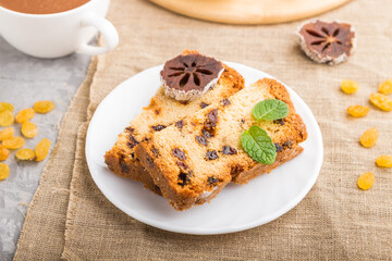 Homemade cake with raisins, dried persimmon and a cup of hot chocolate on a gray concrete background. side view, selective focus.